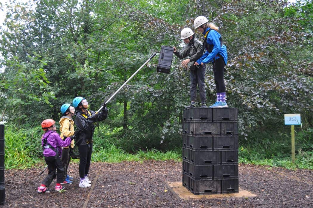 KS3 children participate in exciting crate staking adventure activity within the centre grounds