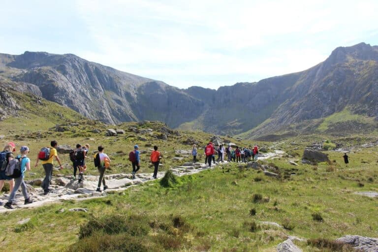 Primary school children hike through Eryri mountains as fun adventure activity