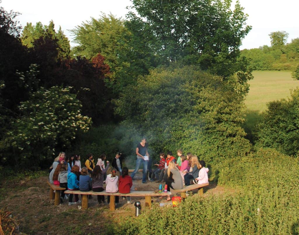 Students sat around a story circle after a day of outdoor learning