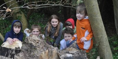 Kids behind wood pile
