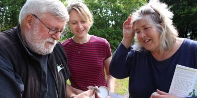 three people looking at a moth trap