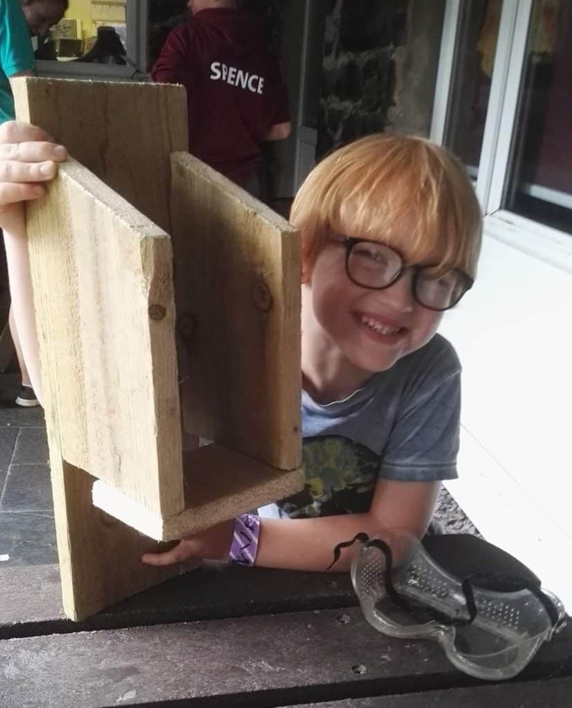 A boy with a birdhouse he has made