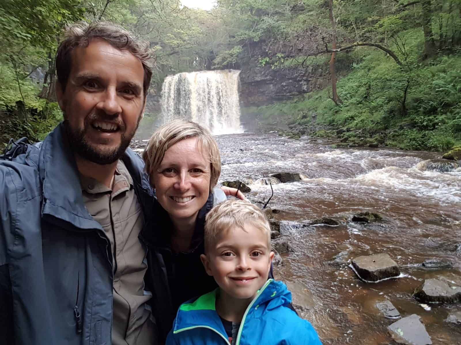 Family selfie in front of a waterfall