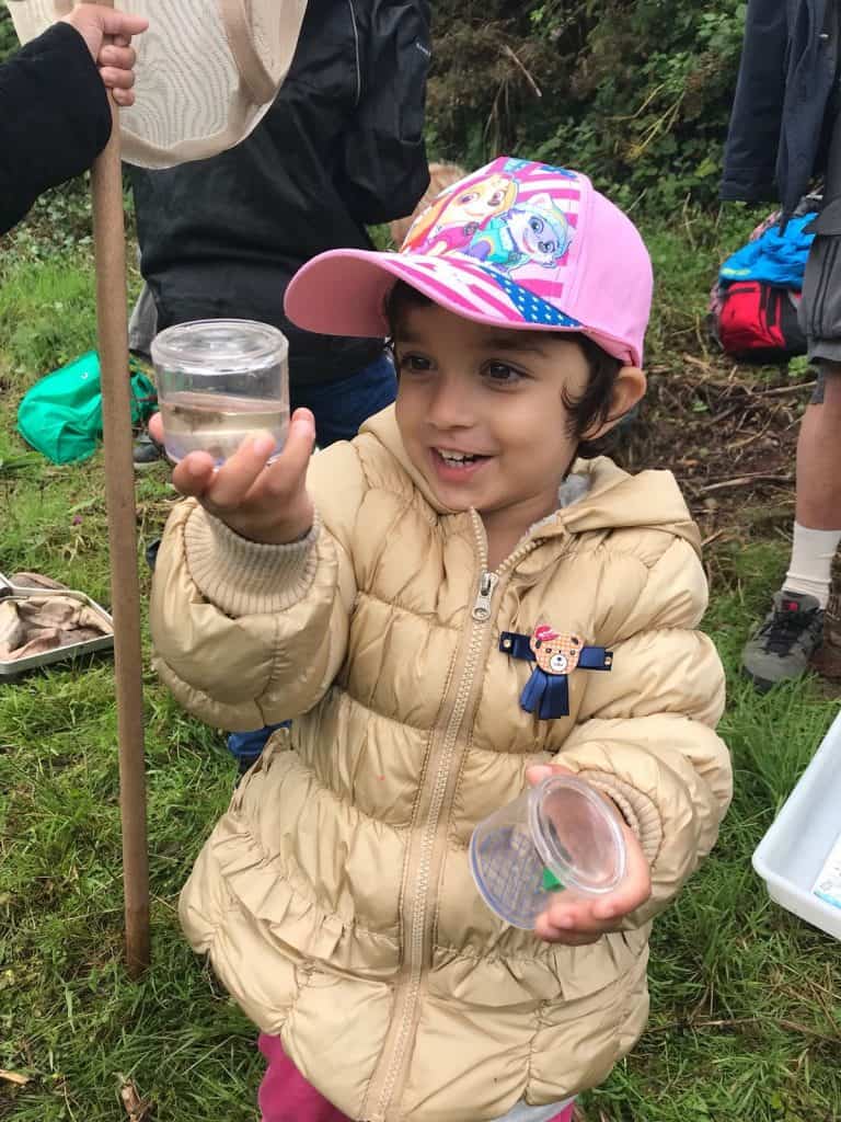 Young female child holding up species in a pot