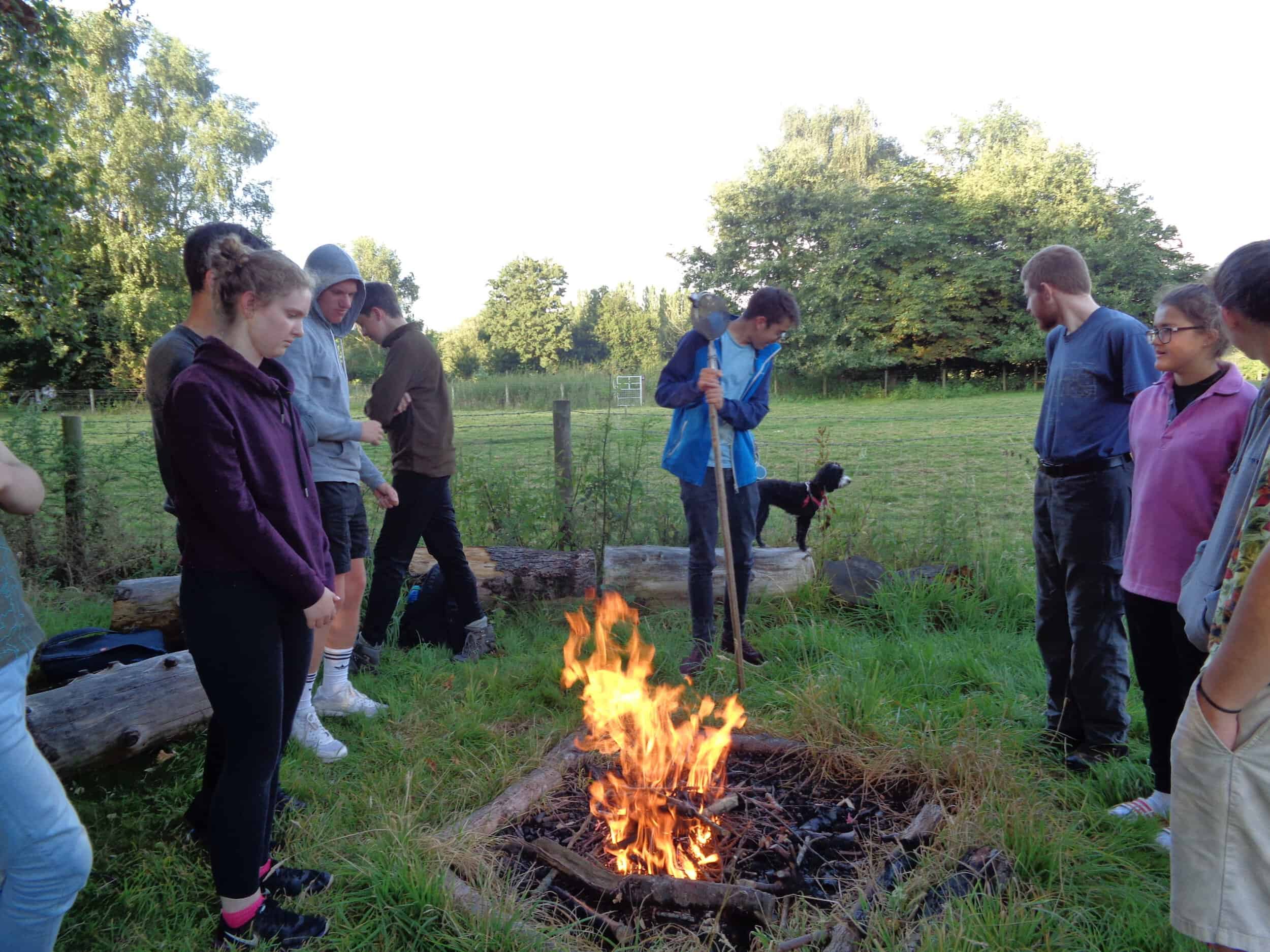 Growing Confidence members around a campfire