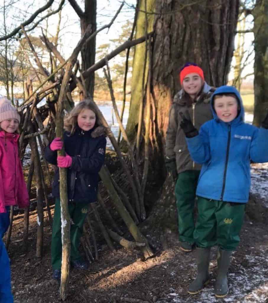 children infront of their den in the snow