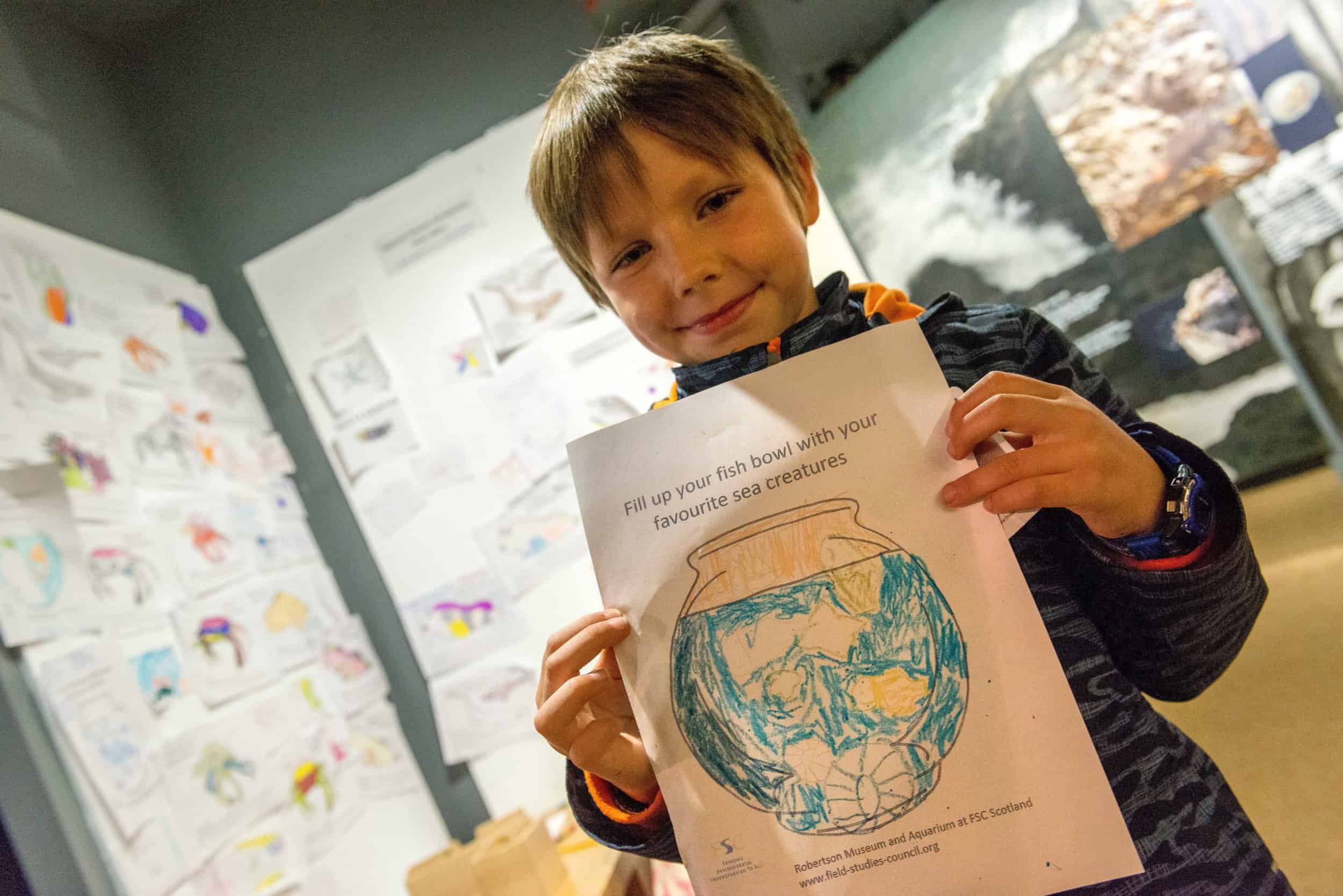 Little boy with a Robertson Museum and Aquarium activity sheet