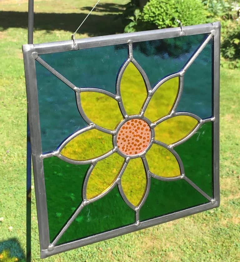 Astained glass square with a flower in the middle