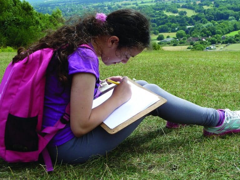Child with a clipboard in the countryside