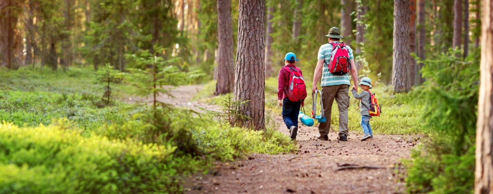 Father and boys going camping with tent in nature