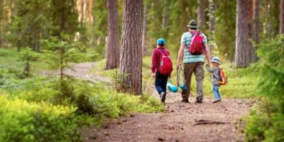 Father and boys going camping with tent in nature