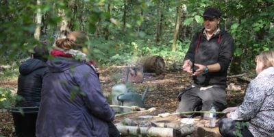 A tutor talking to a student in woodland
