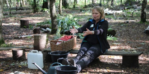 A tutor sat on a log talking