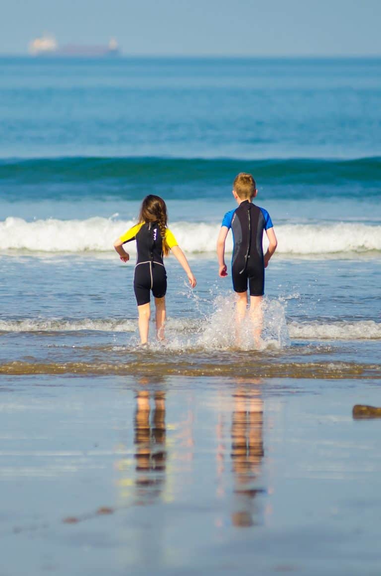 Two children running into the sea in Pembrokeshire
