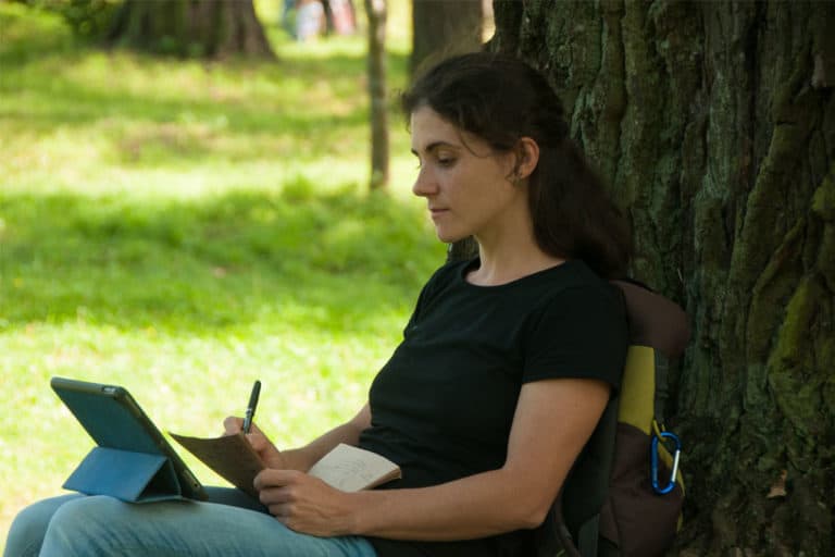 Lady against tree with ipad