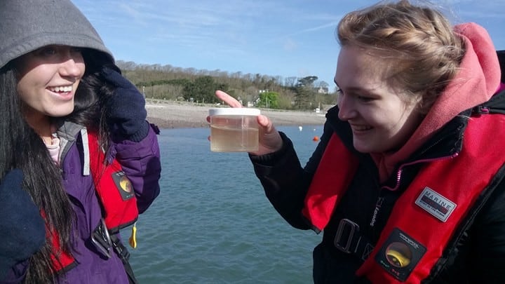 smiling girls studying marine life