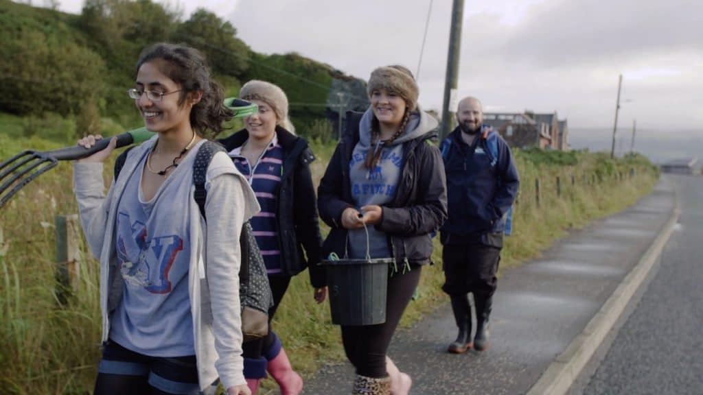 smiling biology group walking to field site