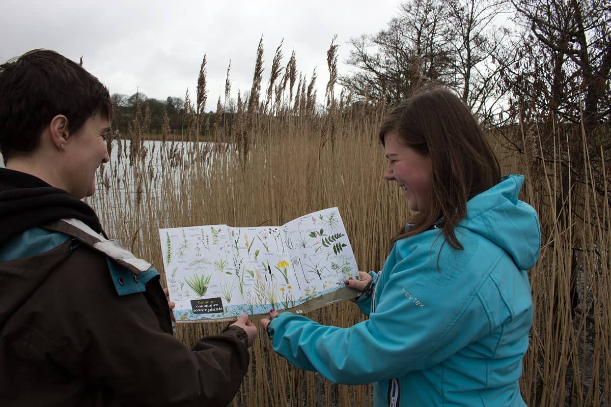 two girls looking at fold out chart