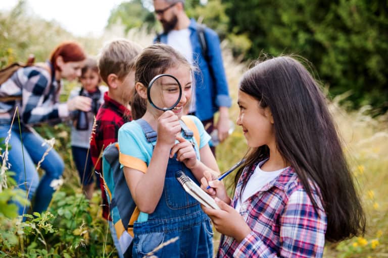 primary school children with magnifying glass