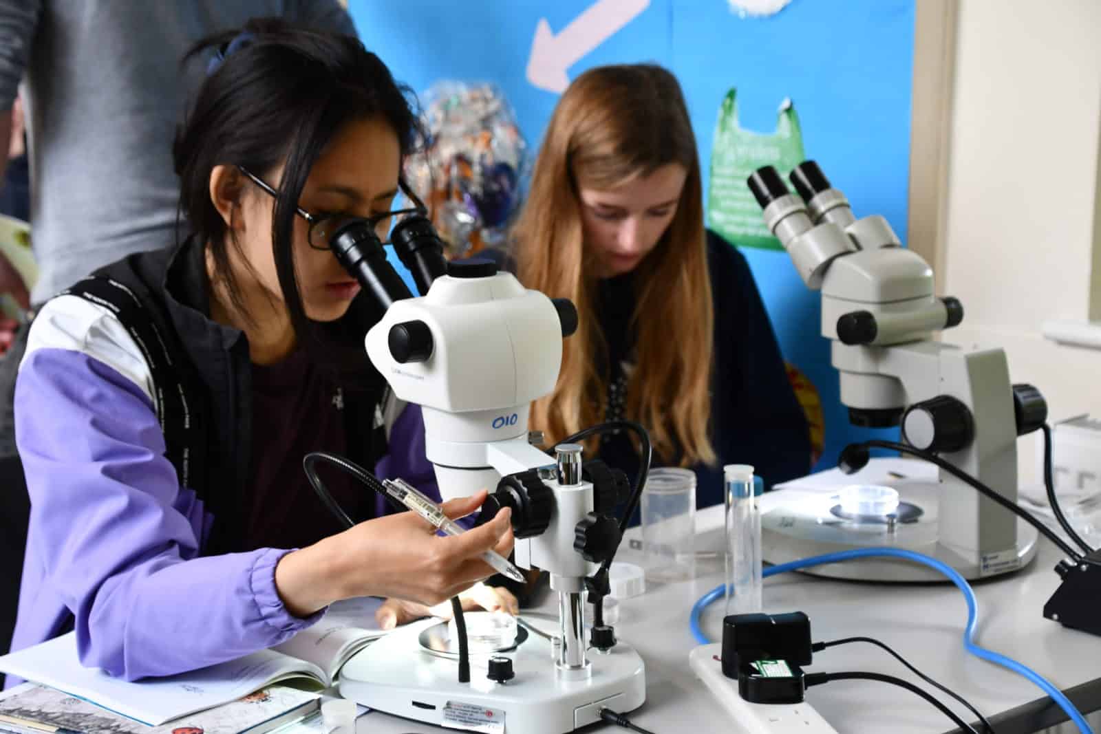 Young people looking in to microscopes