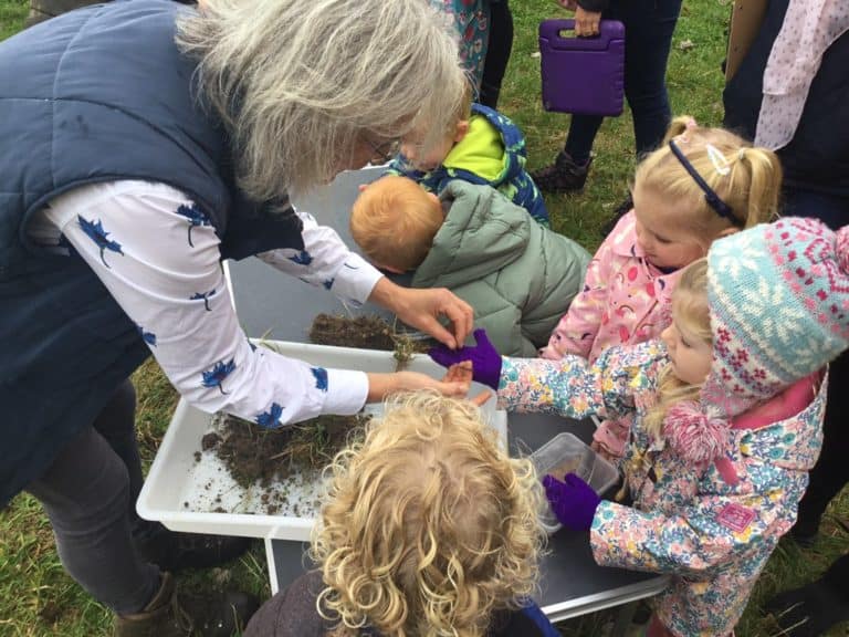 group of children looking at worms