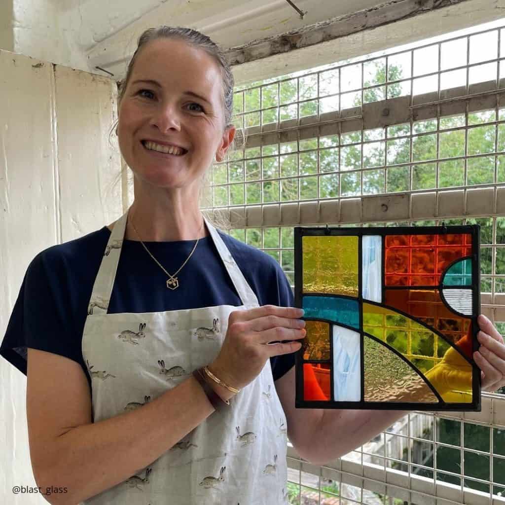 Lady with glass panel made on a Field Studies Council stained glass course.