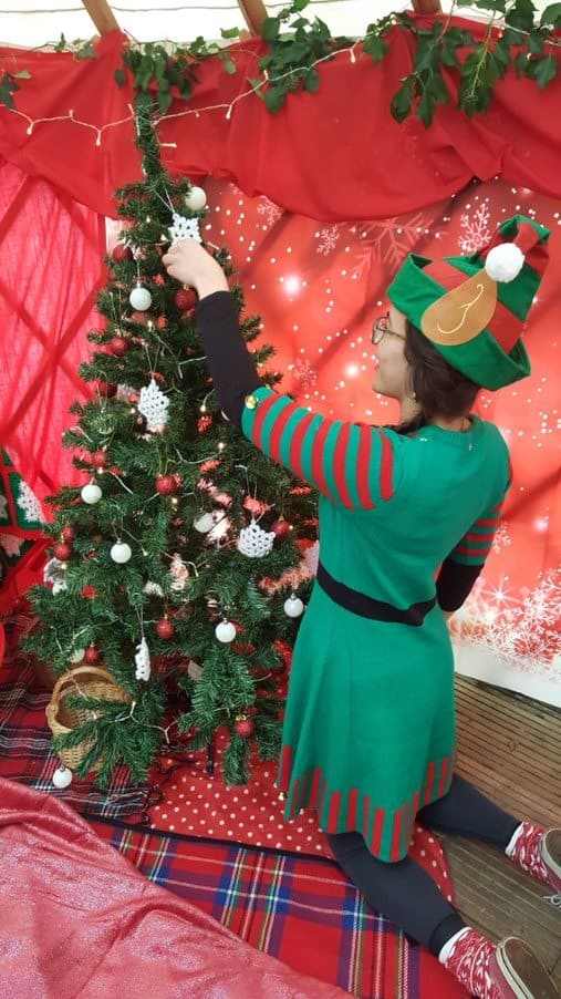 elf decorating a tree