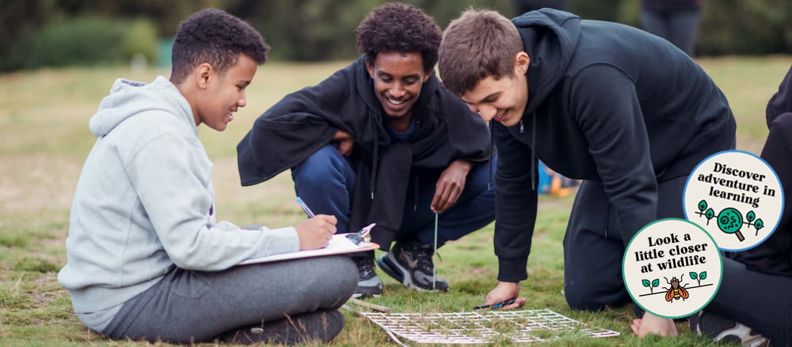 three boys smiling looking at a transect