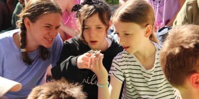 three girls looking at a moth