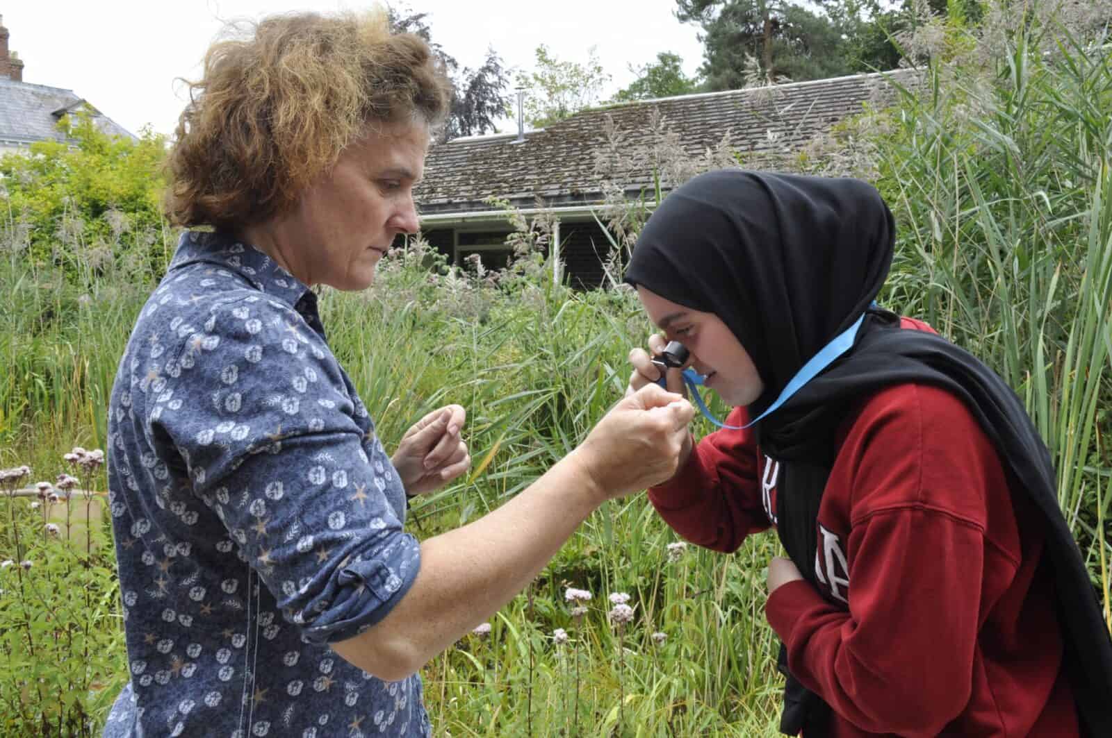 tutor and young person using a hand lens