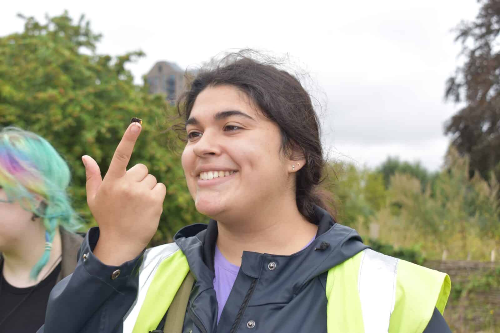 smiling girl with insect on finger