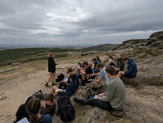 A group of people listening to someone stood in front of them