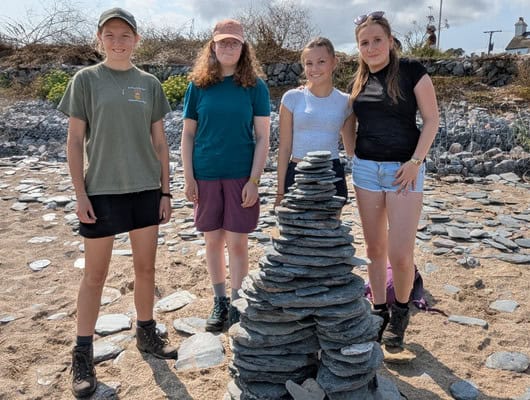 A group of girls behind a rock tower
