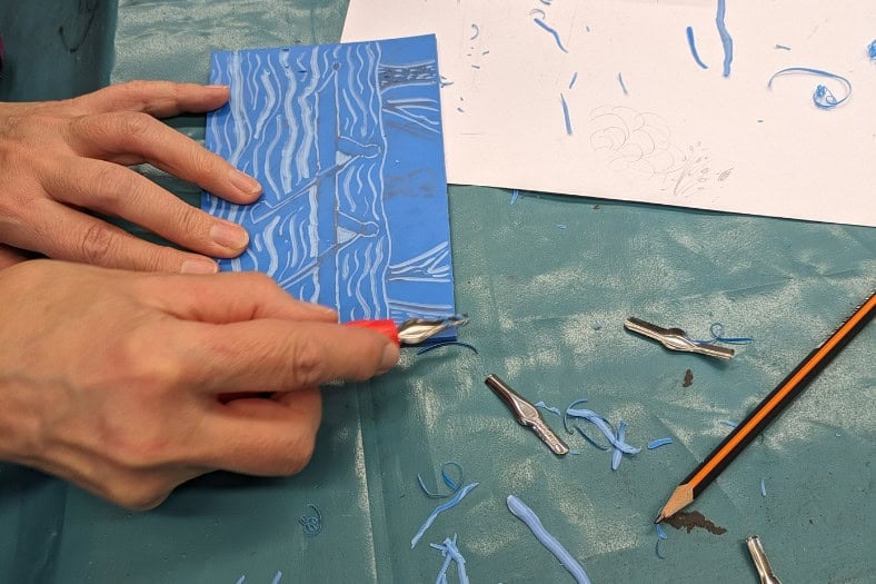 Someone cutting lino during a Lino cutting and printing course