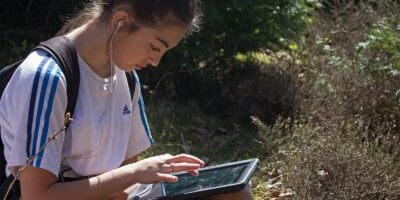 girl outdoors looking at a tablet