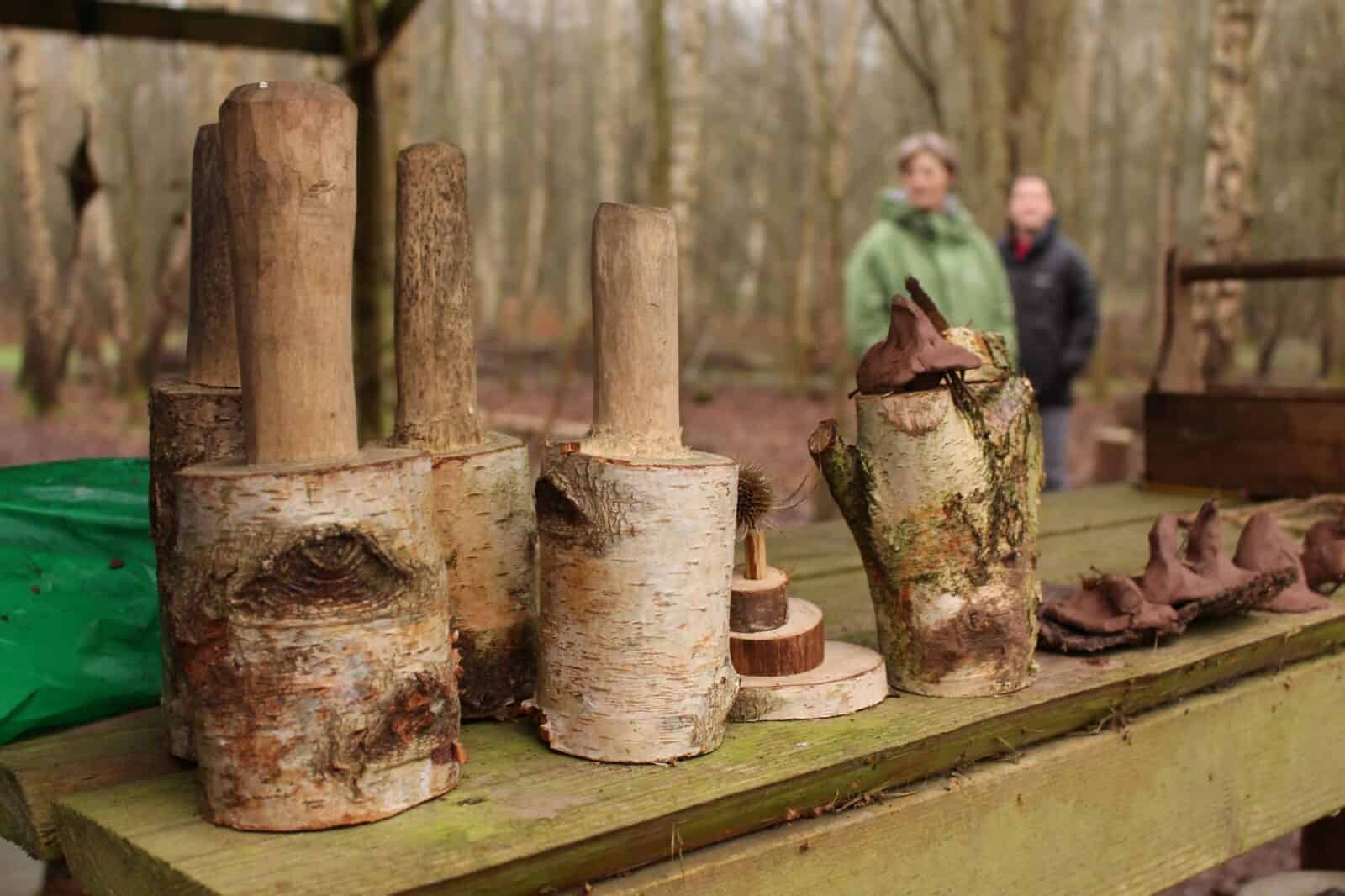 3 hand made mallets on a bench with people in the background
