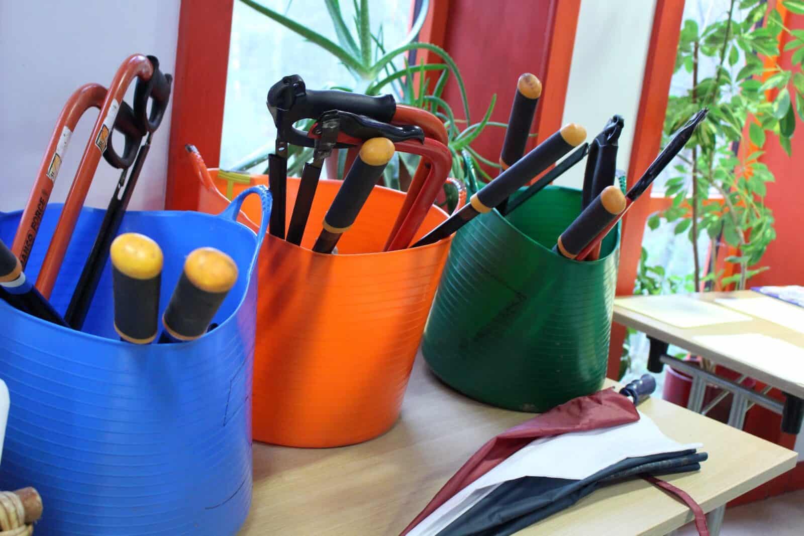 3 bright buckets full of gardening tools