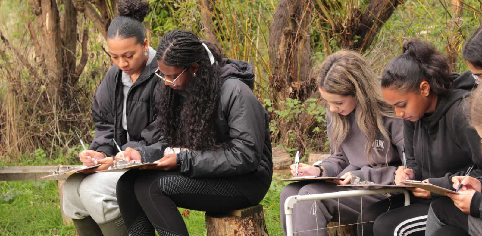 girls working on clipboards outdoors