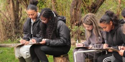 girls working on clipboards outdoors