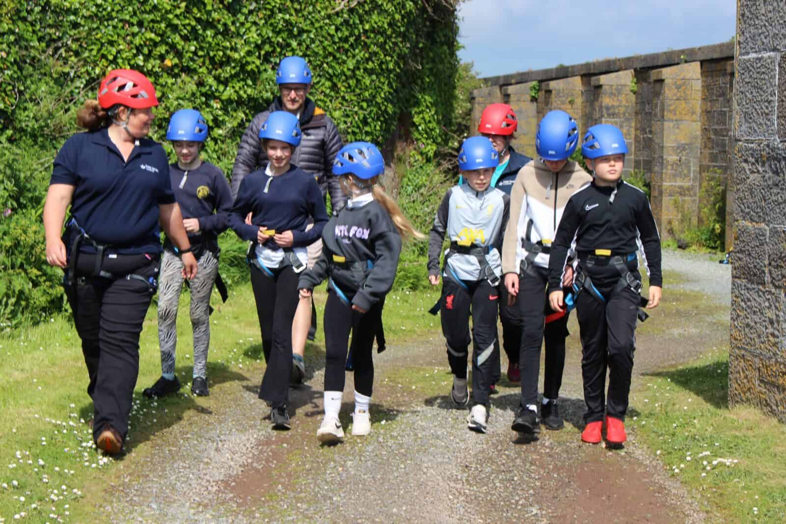 Tutor leads a primary group for adventurous activity at centre - climbing wall school group