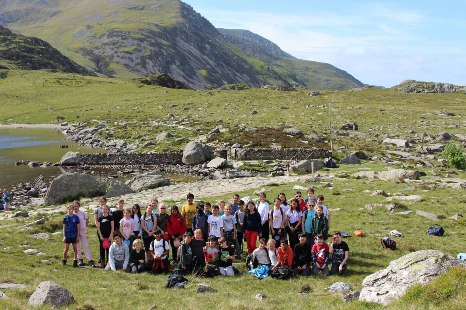 Group of primary school children in front of a lake in Welsh mountains
