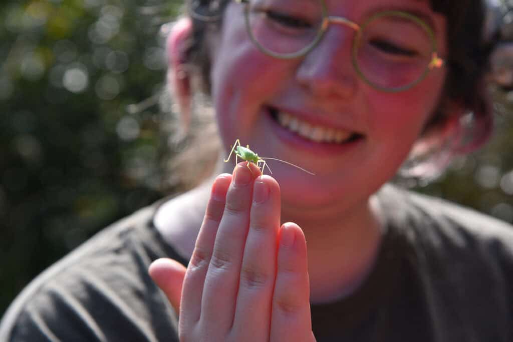 smiling girl holding insect