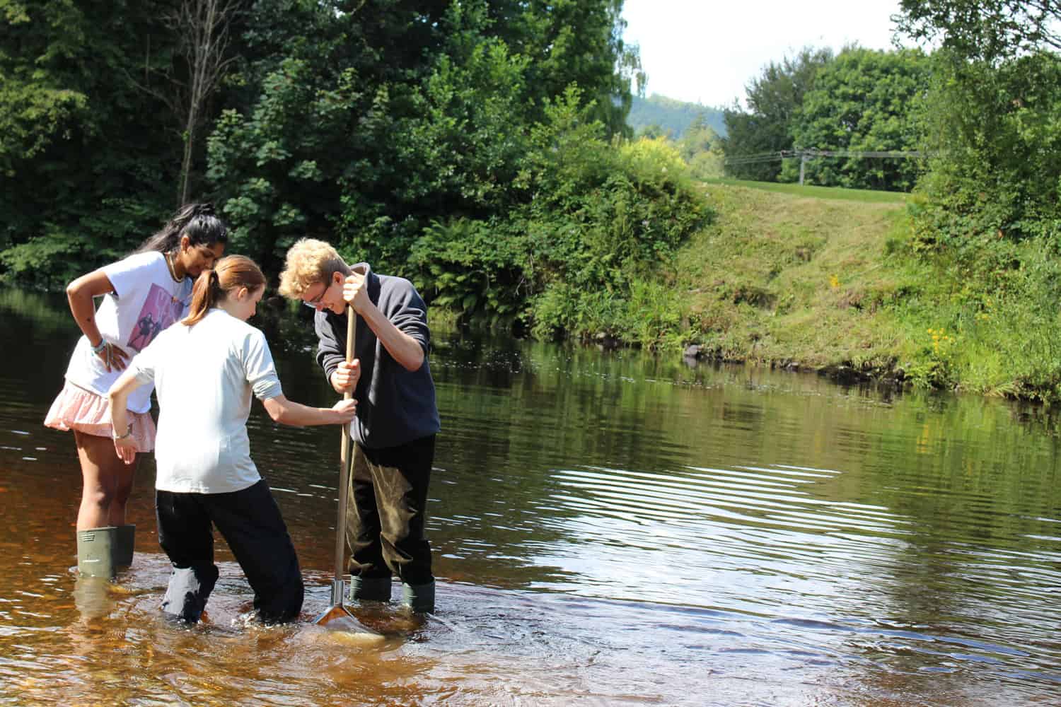 group of young people in the river with net