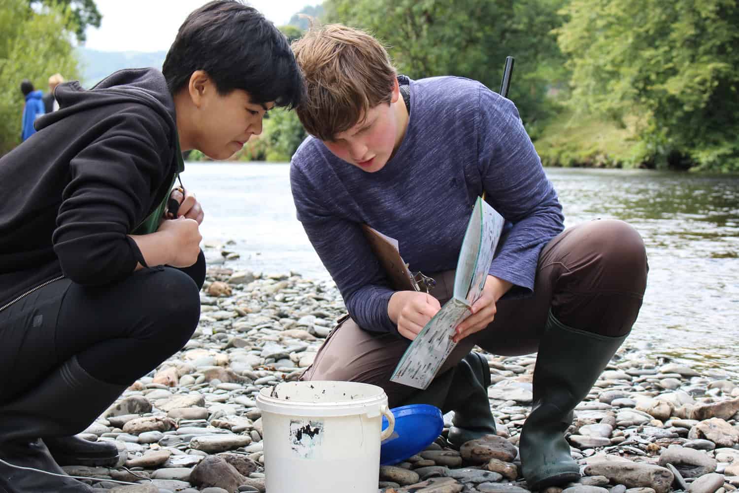 two boys identifying river wildlife