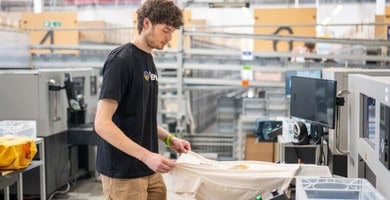 a man printing on a t-shirt in a factory