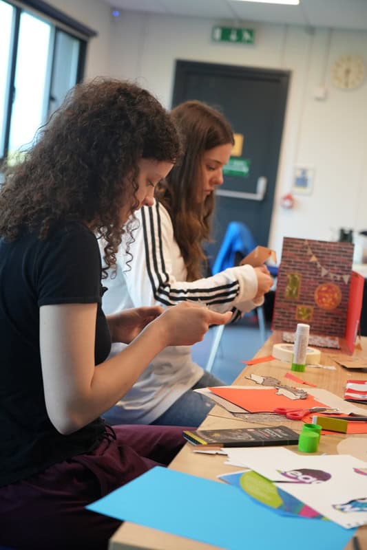 Young people sat at a table crafting - Art Camp