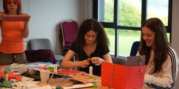 Young people sat at a table crafting - Art Camp