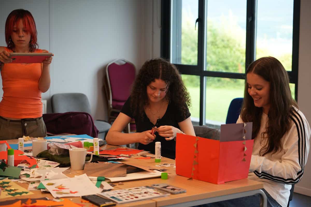 Young people sat at a table crafting - Art Camp