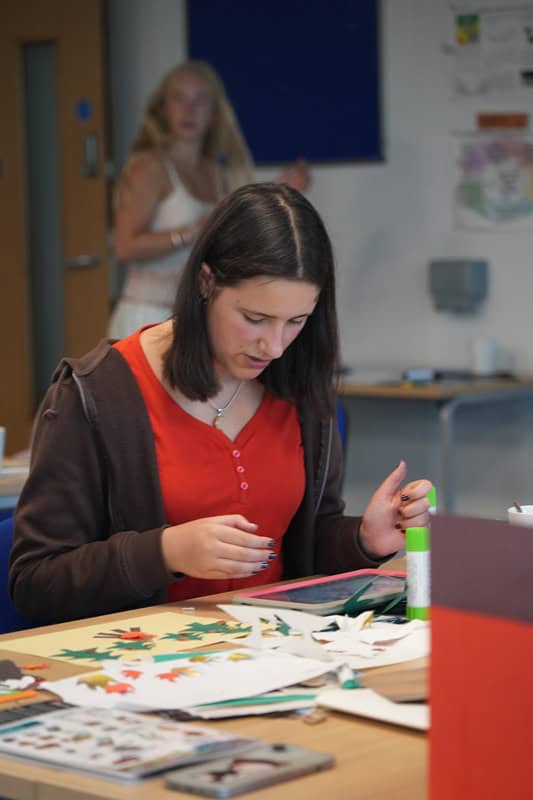 a young person sat at a table crafting - Art Camp