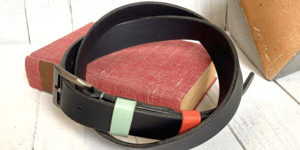 A dark brown leather belt on a red book